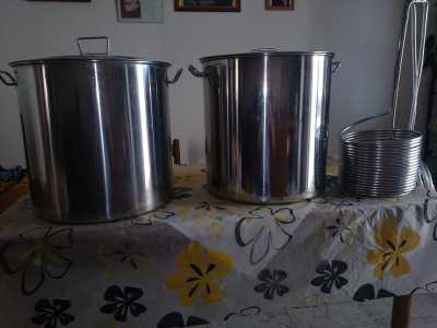 Due pentole in acciaio inox e una serpentina, strumento utilizzato per raffreddare il mosto caldo